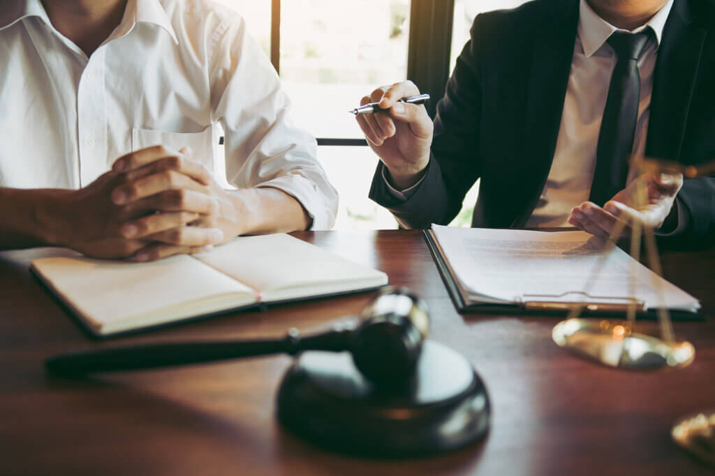 A man in a suit providing federal employment law training to a man in a white suit.